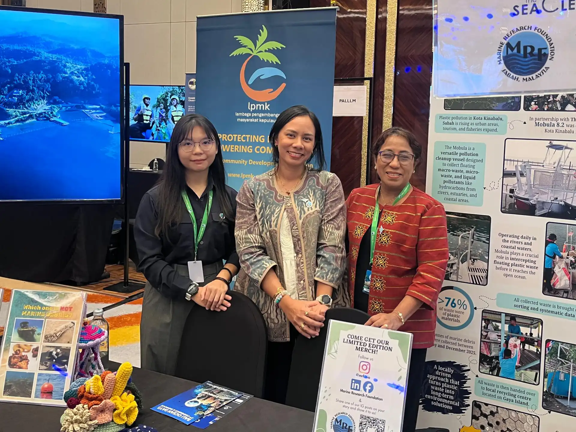 Three women at environmental conservation booth in Bali.